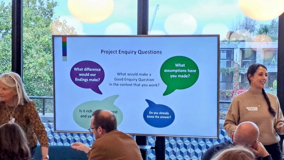 Group of teachers taking part in the Teacher Development Fund. Two women stand in front of screen with a power point presentation