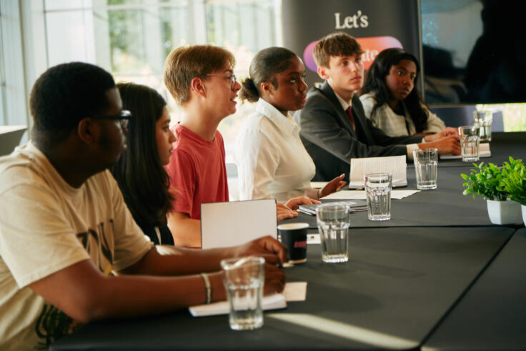 Young people sit at a board table at a My Life My Say event.